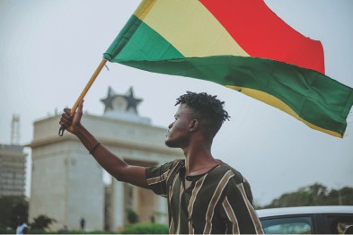A Man Holding Up Ghana Flag A Man Holding Up Ghana Flag